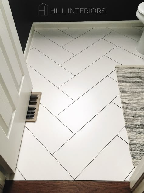 White Tile Herringbone Floor, White Herringbone Tile Black Grout, White Tile Floor Dark Grout, Large Tile Herringbone Floor, White Tile With Black Grout Floor, White Tile Dark Grout Kitchen Floor, Bathroom Floor Tile Black Grout, Powder Room Herringbone Floor, White Chevron Floor Tile