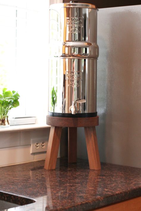 Handmade wood countertop stand compatible with the Berkey water filtration system. Available in multiple diameters, please choose the correct size to fit your needs. The stand is designed to be 1/2” larger than the bottom diameter of your Berkey. This stand raises the water dispenser off the counter so that a glass can be conveniently filled under the spigot. Also works great as a plant stand or wood riser. Stand DimensionsOverall Height 9” (all sizes) - Leg Height 7.5”Stand DiameterTravel Berke Diy Berkey Water Filter Stand Ideas, Counter Top Water Dispenser, Diy Berkey Stand, Diy Water Dispenser Stand, Berkey Stand Ideas, Berkey Water Filter Stand Ideas, Berkey Filter, Water Filter Stand, Kitchen Sink Stand