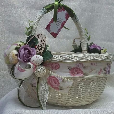 I LIKE THE STYLE OF THIS BASKET. USE CHAMPAGNE OR PEARL COLOR BASKET, W/ GOLD SPARKILLY RIBBON AROUND THE TOP PART OF THE BASKET, WITH LITTLE DIAMONDS & PEARLS PUT ON ALL AROUND THE BASKET, LINED ON THE INSIDE OF THE BASKET W/ (MY COLOR'S: PURPLE, GOLD, CHAMPAGNE/PEARL) SOME PRETTY FABRIC/MATERIAL, ALSO ADD A PRETTY CHARM/ORNAMENT HANGING DOWN FROM THE MIDDLE OF THE HANDLE & MY FAVORITE PURPLE FLOWERS @ THE BASE ON EACH SIDE OF THE BOTTOM OF THE HANDLE. (LIKE IT LOOKS IN THE PIC). Handle Ideas, Basket Flower Arrangements, Basket Handle, Diy Bridal Bouquet, Easter Craft Decorations, Wedding Gift Wrapping, Spring Decor Diy, Flower Girl Baskets, Easter Projects