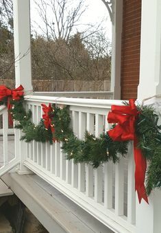 Garland Front Porch Railing, Christmas Garland Outdoor Pillars, Porch Banister Christmas Decor, Christmas Porch Decor Garland, Porch Railing Christmas Decorations, Garland On Outdoor Railing, Outdoor Christmas Garland Porch, Christmas Porch Garland Ideas, Christmas Front Porch Garland