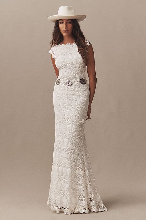 The Daughters of Simone Lilah Cap-Sleeve Crochet Lace Wedding Gown is a romantic masterpiece, blending bohemian charm with timeless elegance. Its delicate crochet lace detailing, chapel-length train, and whimsical cap sleeves create a dreamy silhouette that exudes effortless grace, perfect for the free-spirited bride seeking a touch of vintage-inspired allure on her special day. | Lilah Cap-Sleeve Crochet Lace Wedding Gown by Daughters of Simone in White, Women's, Size: Small, Cotton/Nylon/Elast Crocheted Wedding Dress, Crochet Wedding Dress, Wedding Dress Traditional, Daughters Of Simone, Bhldn Wedding Dress, Crochet Wedding Dresses, White Crochet Dress, Sheath Wedding Gown, Lace Wedding Gown