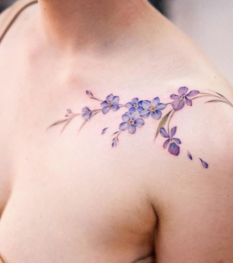 21 Alluring Violet Flower Tattoos For A Delicate Expression Violate Flower Tattoo, Violet Shoulder Tattoo, Wild Violets Tattoo, Violet Collarbone Tattoo, Violet Vine Tattoo, Violet Flower Tattoo Color, Purple Violet Tattoo, Violet Flower Tattoo Designs, Clematis Tattoo