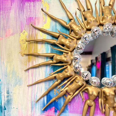 I don't make perfect art, but this mirror is about as close as it gets! This Disco Barbie Golden Sunburst Mirror is made with a mix of 15 vintage and modern Barbies circling a round 10" mirror. It measures a total of 28" toe to toe, weighs about 5 lbs, and is made with an easy-to-hang picture wire on the back. The first of these mirrors is hanging in my house, and over the last year it has gone viral on both Reddit and Facebook. Join the fun and get your own one-of-a-kind Barbie mirror, and keep Birdcage Repurpose Ideas, Barbie Office Decor, Junk Mirror, Yarn Mirror, Funky Mirror Ideas, Garage Hangout Ideas, Disco Bathroom, Barbie Mirror, Disco Barbie