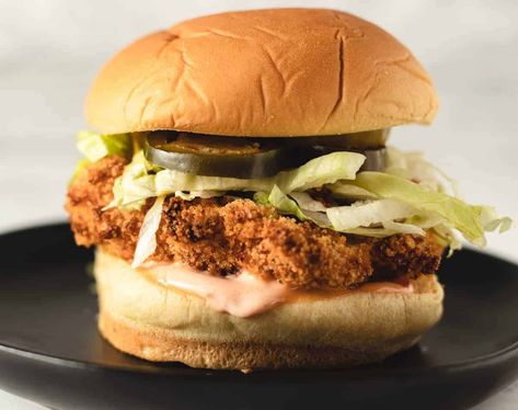 Air Fryer Chicken sandwich with sauce and lettuce sitting on a black plate. Air Fryer Chicken Mayo, Air Fried Chicken Thigh Sandwich, Spicy Chicken Sandwich Air Fryer, Crispy Spicy Chicken Sandwich, Spicy Mayo For Chicken Sandwich, Spicy Chicken Sandwiches, Crispy Fry, Potato Roll, Spicy Mayo