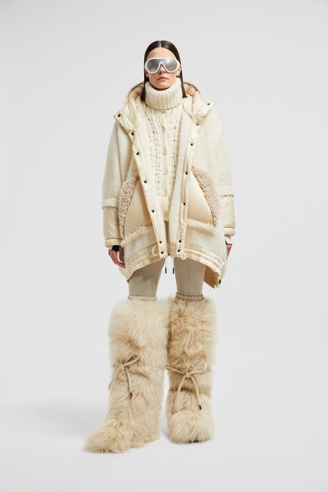 Embodying an après ski mood, this cape is crafted from a luxurious wool, alpaca and mohair blend. The accessory features insulated sleeves and a protective down-filled hood, offering enhanced warmth. The warmer is completed by a curly shearling trim. Aspen Ski Outfits, Moncler Runway, Ski Apres Outfit, Womens Ski Fashion, Apres Ski Fashion, Nyc Winter Outfits Cold Weather, Cute Ski Outfits For Women, Vintage Apres Ski, Cabin Fashion