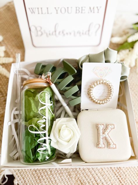 What better way to ask your Bridesmaids to join your Bridal Party than with our ADORABLE Bridesmaid Gift Boxes?!!                 Our boxes are Personalized with a shimmery rose gold cursive name on the outside of the white box and you can choose your wording to fit your recipient for the inside of the box.  You Choose the wording from the drop down menu.  For example choose Bridesmaid for it to say  "Will you Be My Bridesmaid". You can also choose no wording inside the box.  We offer 3 sets to choose from : BASIC , PREMIUM & DELUXE. Choose your type from the drop down menu. BASIC includes Personalized Gift Box, Personalized Glass Tumbler with lid & straw, Foam Rose, Diamond Pen, and Satin Scruchie PREMIUM includes Personalized Gift Box, Diamond Hair Tie, Personalized Tumbler with Lid & St Blanket Bridesmaid Gift, Simple Bridesmaid Proposal Gift, Bridal Party Invites Bridesmaid, Pearl Bridesmaid Proposal, Sage Green Bridesmaid Proposal Boxes, Beachy Bridesmaid Proposal, Asking Your Bridesmaids Ideas, Wedding Boxes For Bridesmaids, Wedding Party Boxes