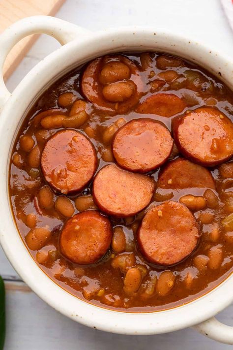 These Texas style baked bean are an excellent side dish that can also serve as a great dinner too. This recipe is easy because it doesn't rely on dried beans, and you don't even need the your oven--they cook up in a skillet or dutch oven right on your stove top. Smoked sausage, chili powder, and jalapeño adds tons of flavor and a piece of corn bread rounds out the dish in true Texas, or Southern style. Smoked Sausage Cowboy Beans, Texas Baked Beans Recipe, Authentic Enchilada Sauce, Bologna Recipes, Sausage Chili, Chile Colorado, Chili Beans, Cowboy Beans, Beans And Sausage