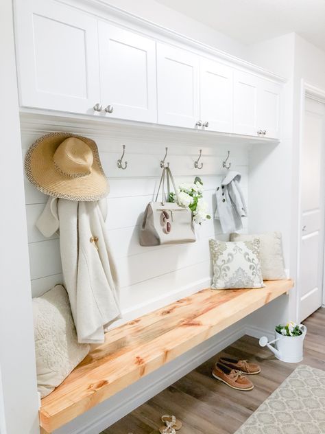 White and raw wood mudroom built-in with shiplap accents, closed upper cabinet storage, backer board with decorative hooks and floating bench. Mudroom Upper Cabinets, Mudroom Hooks And Bench, Floating Bench Seat, Wood Mudroom, Floating Bench, Sala Vintage, Built In Bench Seating, Small Mudroom Ideas, Farmhouse Mudroom