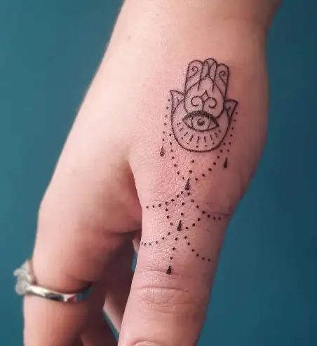 Hamsa Finger Tattoos For Women, Hand Of Miriam Tattoo, Unique Women Tattoos Inspiration, Hamsa Tattoo Simple, Thumb Tattoos For Women Unique, Mandala Small Tattoo, Hamsa Evil Eye Tattoo, Thumb Tattoos For Women, 3x3 Tattoos Ideas