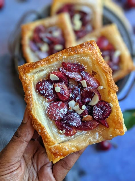 This Cherry Pastry Tart is the perfect dessert that is easy to make and delicious. This rustic cherry tart smothers a puff pastry crust with fresh cherries, and almonds. It’s a stunning summer dessert with its purplish summer stone fruit. Ideal for dessert and, if you can manage to save a slice, for breakfast as well. Cherry Puff Pastry Dessert, Cherry Puff Pastry Recipes, Cherry Pastries, Cherry Pastry Recipes, Fruit Puff Pastry, Cherry Puff Pastry, Cherry Pastry, Cherry Tarts, Breakfast Tarts