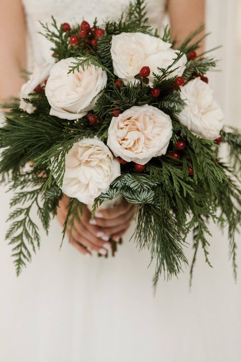 Christmas wedding; wedding bouquet; white garden roses; cedar; red coffee berry; pine   Lisa Foster Floral Design   www.lisafosterdesign.com Winter Pine Bouquet, Pine And Rose Bouquet, Holly Wedding Bouquet, White Roses Winter Wedding, Flowers For A December Wedding, Bridesmaid Bouquet Christmas, December Bouquet Wedding, Christmas Themed Bouquet, Winter Wedding Flower Bouquets