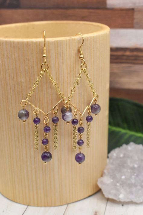 These earrings are delightfully stylish, combining the purple hues of amethyst with delicate golden chains that sway and glitter with every step and turn. They come on golden, nickel free ear wires with rubber rubber backs to keep them securely on your ears. They would make a great addition to your own collection, or a beautiful gift for a loved one! Chandelier Earrings Diy, Wire Wrap Earrings, Gemstone Jewellery Design, Crystal Bead Jewelry, Sweet Earrings, Earrings Chandelier, Wrap Earrings, Fancy Earrings, Diy Wire Jewelry