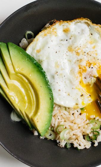 Brown rice—higher in fiber and other nutrients than its white counterpart—is the perfect vehicle for this quick, protein-heavy lunch. Avocado Dessert, Eating Plan, Think Food, Avocado Recipes, Rice Bowl, Meatless Meals, Fried Egg, Bowls Recipe, Brown Rice