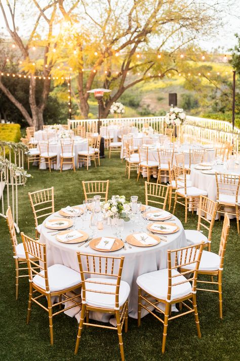 Gold chiavari chairs, herb napkin treatments, gray linen with gold chargers and gold floral vases/towers with white & green florals helped create our "south of France" vibe. #africanwedding #ghanaianwedding #englishwedding #multiculturalwedding #losangelesweddingplanner #goldwhitegray #goldchiavarichairs #stringlights #goldchargers #graylinen #delmarevents #Kellogghouse #munaluchibride Chiavari Chairs Wedding, Hummingbird Nest Ranch Wedding, Wedding Reception Chairs, Ghanaian Wedding, Hummingbird Nest Ranch, Gold Chiavari Chairs, Hummingbird Nest, Reception Look, Reception Tables