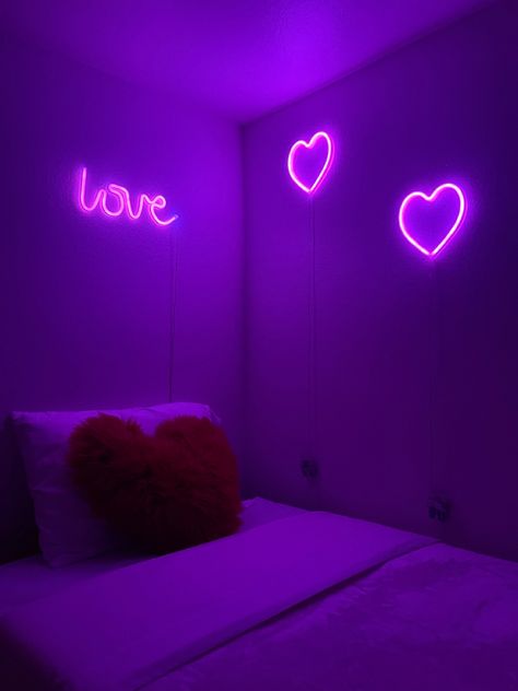 purple dimly lit room, white bed with red fluffy heart pillow, “love” pink neon light, two pink heart neon lights Neon Lights Bedroom Aesthetic, Heart Room Decor, Heart Room, Vibey Room Aesthetic, Vibey Room, Purple Room Decor, Neon Lights Bedroom, Pink Glitter Wallpaper, Indian Room Decor