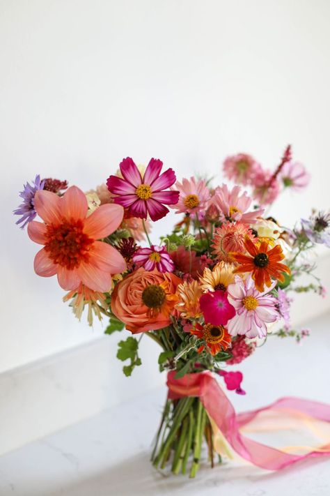 Colourful natural bridal bouquet sits on a marble sideboard Pink Orange Wedding Flowers, Natural Bouquet Wedding, Bright Wedding Bouquet, Summer Bridal Bouquet, Wildflower Bridal Bouquets, Orange Bridal Bouquet, Orange Wedding Bouquet, Orange And Pink Wedding, Colorful Bridal Bouquet