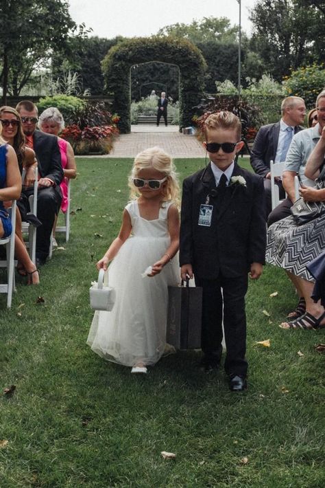 This adorable flower girl rocked cute white sunglasses. The ring bearer wore an adorable "security guard" look with a briefcase, sunglasses, and security tag. Ring Security Briefcase, Security Ring Bearer Boys, Ring Bearer Security Guard, Ring Bearer Aesthetic, Flower Girl And Ring Bearer Ideas, Flower Boy Wedding, Wedding Security, Ring Barrier, Ring Security Ring Bearer