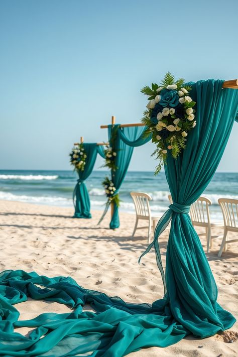 Transform your dream wedding with this elegant beach setup! Featuring stunning teal fabric drapes, lush white and blue floral arrangements, and wooden arches, this oceanfront wedding decor creates a chic and romantic vibe against the backdrop of sandy shores and turquoise waves. Perfect for couples planning a coastal wedding, this Pinterest-worthy image offers inspiration for outdoor wedding arches, tropical ceremony ideas, and beach wedding themes. Save this pin for your wedding planning board! #BeachWedding #WeddingArches #OutdoorWedding #CoastalWedding #TealWeddingDecor White And Blue Floral Arrangements, Outdoor Wedding Arches, Beach Wedding Arches, Teal Beach Wedding, Blue Floral Arrangements, Tropical Ceremony, Beach Wedding Themes, Beach Setup, Wooden Arches