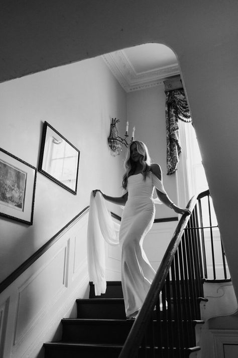 Black and White photo of bride walking down the stairs holding her veil. Bride Coming Down Stairs, Bride Stairs Photography, Editorial Getting Ready Photos, Bride Walking Down Stairs, Wedding Photos Stairs, Bride Stairs, Bride On Stairs, Bridal Photoshoot Ideas, Walking Down Stairs