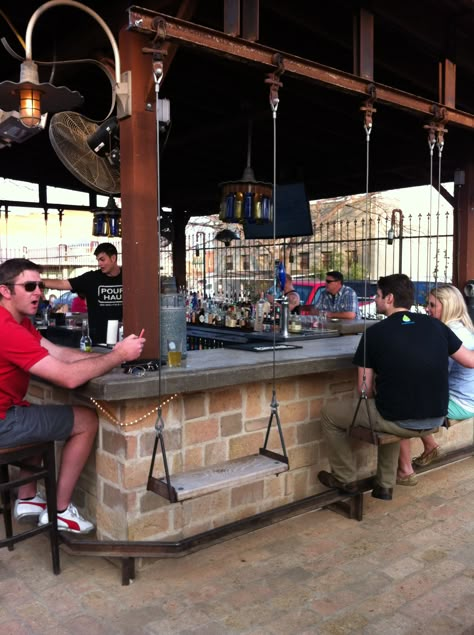 outdoor swings at the bar. they are on rollers and attached to an i-beam. Bar Swings Outdoor, Outdoor Bar With Swings, Bar With Swings, Bar Swings, Opening A Bar, Outdoor Kitchen Layout, Outdoor Swings, Cottage Kitchen Cabinets, Kitchen Bars