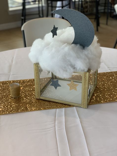 Centerpiece made with photo frames to make a glass box Over The Moon Shower Centerpieces, Star Moon Centerpiece, Moon Stars Centerpieces, Twinkle Twinkle Centerpieces, Table Centerpieces For Baby Shower Boys, Moon And Star Baby Shower Centerpieces, Diy Cloud Centerpieces, Star And Moon Centerpieces, Moon And Stars Centerpiece Ideas