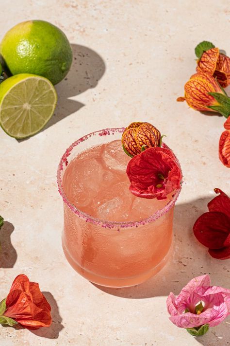 This refreshing floral cocktail is a twist on the classic margarita with the addition of a simple hibiscus syrup. Margarita With A Twist, Wild Flower Party Food, Hibiscus Margarita Recipe, Thumbelina Wedding, Botanical Drinks, Floral Margarita, Flower Cocktails, Flower Drinks, Floral Drinks