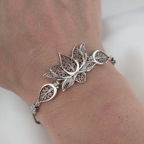 Embrace elegance with every gesture 🌸 Our Lotus Flower Sterling Silver Bracelet is the epitome of grace and handcrafted beauty, perfect for commemorating unforgettable moments. Whether you're seeking a memorable anniversary gift or simply want to add a touch of filigree art to your style, this adjustable charm bracelet is sure to captivate. Click the link to adorn your wrist with this exquisite piece or to gift an everlasting bloom to the one you adore. 🎁✨ #SterlingSophistication #Anniversary... Silver Jewellery Design, Filigrana Jewelry, Money Crown, Lotus Motif, Lotus Flower Jewelry, Silver Bracelet Designs, Silver Bracelet For Women, Flower Woman, Lotus Bracelet