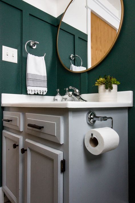 Such a pretty gray painted bathroom vanity! Love the polished chrome hardware and the dark Rainforest green color on the walls. You have to see this gorgeous modern bathroom makeover! #modernbathroom #bathroommakeover #smallbathroom #bathroomdesign Bathroom Ideas Dark Walls, Green Bathroom With Grey Vanity, Dark Green And Gray Bathroom, Dark Green And Grey Bathroom, Gray Painted Bathroom Vanity, Gray And Green Bathroom Ideas, White And Green Bathroom Ideas, Gray And Green Bathroom, Grey And Green Bathroom Ideas