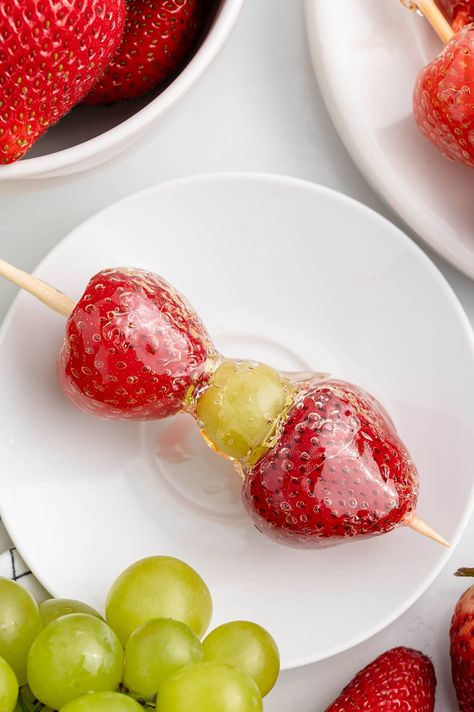 a skewer of Tanghulu with two strawberries and a green grape coated in a glossy, hard candy shell. Grape Kabobs, Strawberry Kabobs, Cheese Dip Mexican, Fruit Sticks, Butterbeer Recipe, Chocolate Turtles, Fruit Skewers, Chocolate Covered Cherries, Apple Cider Donuts