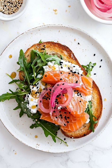 Indulge in a delightful breakfast with this cottage cheese and smoked salmon toast recipe. The creamy cottage cheese perfectly complements the savory smoked salmon, creating a harmonious blend of flavors. This toast is not only delicious but also packed with protein and nutrients to power you through the day. Try making this easy and healthy dish for a satisfying meal that will leave you feeling nourished and ready to take on whatever comes your way.  Ingredients 2 slices toasted sourdough bread Sourdough Cottage Cheese Toast, Savory Toast Ideas, Healthy Breakfast Savory, Toasts Ideas, Salmon Breakfast Recipes, Weekend Lunch Ideas, Cafe Specials, Dinner Toast, Smoked Salmon Toast