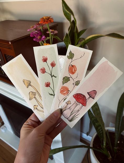 Hand painted watercolor autumn bookmarks. Comes in four different designs: Pumpkins, flowers, wheat/grain, or mushrooms .  Each bookmark is hand painted on watercolor paper. Designs vary from bookmark to bookmark. These make great gifts for the bookworm in your life! Watercolor Painting Gift Ideas, Autumn Watercolor Bookmark, Fall Watercolor Bookmarks, Bookmarks Painting Ideas, Watercolor Bookmarks Ideas, Bookmarks Painted, Bookmarks Autumn, Chocolate Painting, Watercolor Flower Card