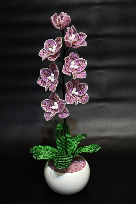 An orchid made of beads, made according to the author 's pattern by hand. Several shades of beads were used in the 5 of the orchid. The orchid is embedded in a ceramic flower vason. The height of the orchid in the vason is 45 cm. Beaded Orchid, Flower Orchid, Beaded Flowers Patterns, French Beaded Flowers, Lavender Bouquet, Artificial Orchids, Crocheted Items, The Orchid, Ceramic Flower