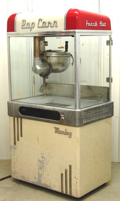 Here is a Manley model 32 Aristocrat popcorn machine.  This model was introduced in 1950.  It would have been one of the most popular models of the early 1950s.  There are several variations to this model including one with neon lights to light up the popcorn.  On each side of this model are two recessed handles.  Many owners do not even know that these handles exist. Aesthetic Popcorn Machine, Movie Theater Popcorn Machine, Vintage Soda Machine, Vintage Popcorn Machine, Coin Op Machine, Popcorn Stand, Copper Moonshine Still, Vintage Coin Operated Rides, Popcorn Machine