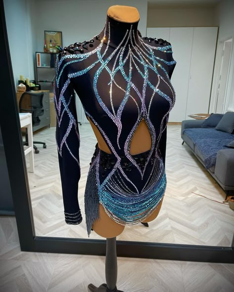 The rhinestoning on this black dance costume is pretty dramatic and creates lots of vertical, slimming design lines. The high collar neckline and diamond cutout also create tall visual lines that add the illusion of more height. This costume has a short 'skirt' formed by draped beads, which look pretty cool, but can also be dangerous on the dance floor if they break. Dance Costume Ideas, Freestyle Dance Costumes, Black Dance Costumes, Salsa Outfit, Latin Competition Dress, Ballroom Dress Inspiration, Rhinestone Costume, Dancesport Dresses, Dance Competition Dress