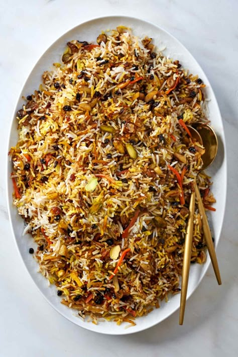 Traditionally served at weddings, this delicious jeweled rice brings sweetness to new couples. This regal rice is filled with dried fruit, nuts, and candied orange peel. You aren't ready for how gorgeous and tasty this is! Fruit And Meat Recipes, Red Rice Recipes, Persian Jeweled Rice, Adas Polo, Zereshk Polo, Persian Food Iranian Cuisine, Jeweled Rice, Dill Rice, Rice Lentils