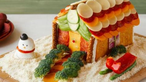 This gingerbread house is overflowing with cheeses, meats and veggies. How To Make A Charcuterie House, Vegetable Gingerbread House, Veggie Gingerbread House, Cheese Gingerbread House, Savory Gingerbread House Ideas, Savory Gingerbread House, Charcuterie Gingerbread House, Charcuterie House For Christmas, Charcuterie Houses