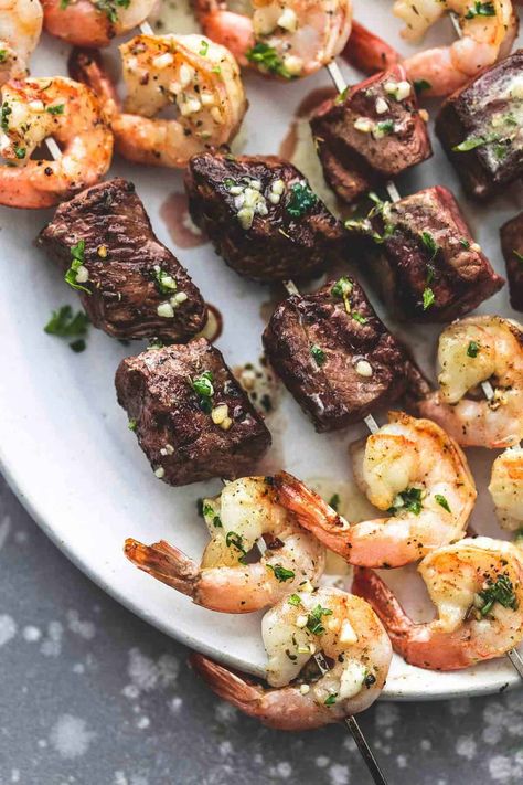 These Garlic Butter Surf and Turf Kabobs are everything you want in a kabob — beef and seafood, on the grill, with that lemony, garlicky, smoky taste you yearn for at the end of a long, hard weekend when you just want to sit back and enjoy a delicious meal with those you love. Surf And Turf Kabobs, Shrimp Kabob Recipes, Teriyaki Steak, Kinds Of Steak, Shrimp Kabobs, Steak And Shrimp, Kabob Recipes, Steak Butter, Surf And Turf