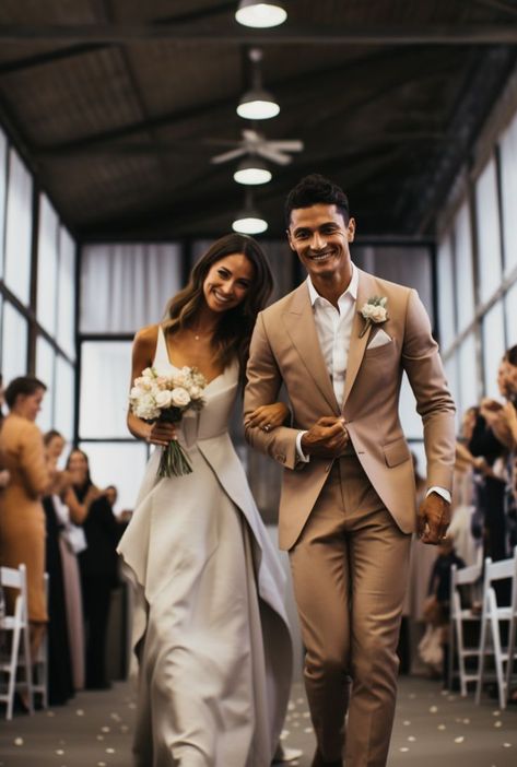 A bride and groom, hand in hand, walking down the aisle, their wedding attire radiating in dark beige and white. The scene captures the essence of pop inspo and the beauty of ready-made artistry, marking a moment of pure love and commitment. Tan Suit With Black Shirt, Beige And White Outfit Men, Taupe Tuxedo Wedding, Groom Attire Tan, Old Money Groom Suit, Tan Suit Black Tie, Light Brown Groomsmen Suits, Groom Beige Suit Wedding, Groom Suit Bow Tie