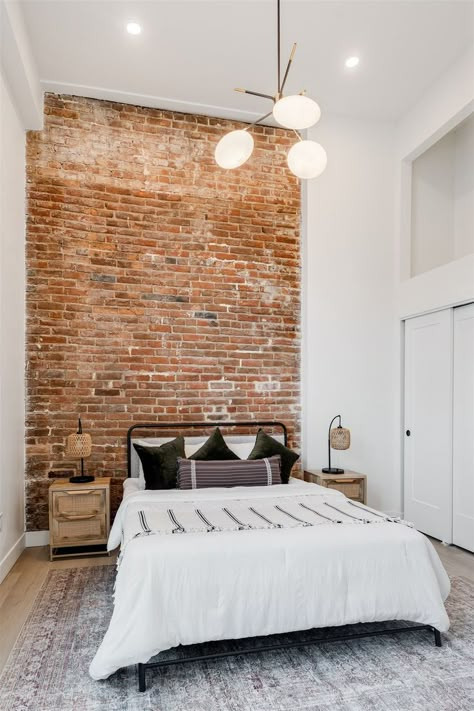 Modern bedroom with modern light fixture and brick feature wall White Exposed Brick Bedroom, Red Brick Bedroom Wall, Brick And Paneling, White Brick Bedroom Ideas, Brick Slips Bedroom, Bedroom With Brick Fireplace, Bedroom Ideas With Brick Wall, Rustic Brick Bedroom, Brick Wall Apartment Decor