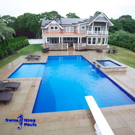 Now we just need some sunshine! This pool has all the bells & whistles: spillover spa including two sleek water features, an extra-large, custom-built sun deck for soaking up the sun, an 8-ft long diving board if you're feeling adventurous, and immaculate landscaping to boot! #Backyardgoals #SwimKingLI Large Swimming Pools, Rectangular Pool Ideas Backyard, Deep Pool Ideas, Large Rectangular Pool, Inground Pool Designs With Sun Shelf, Rectangle Pool With Diving Board, Pool With Slide And Diving Board, Large Rectangle Pool, Rectangle Pool With Raised Spa And Sun Shelf