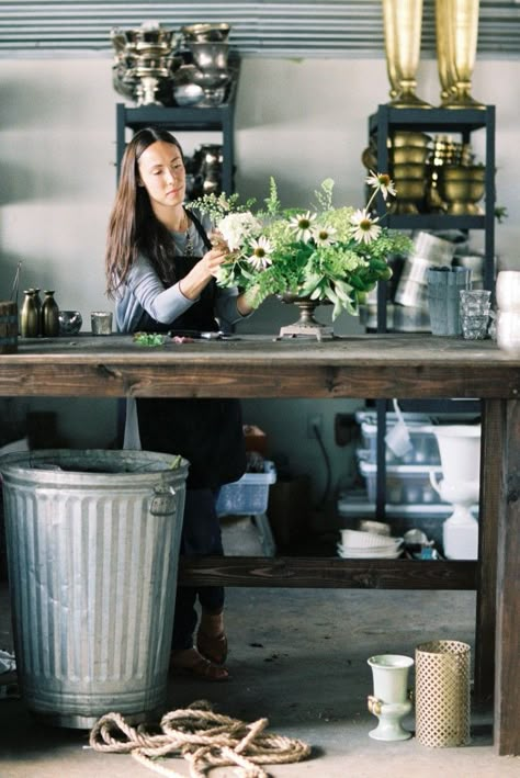 big, tall wood table with durable top, big garbage can, racks for hard goods...Honey of a Thousand Flowers // Sarah Winward Vase Storage Ideas, Floral Studio Work Spaces, Florist Studio Workspace, Florist Table, Shop Interiors Boutique, Vase Storage, Metal Backsplash, Sarah Winward, Industrial Studio