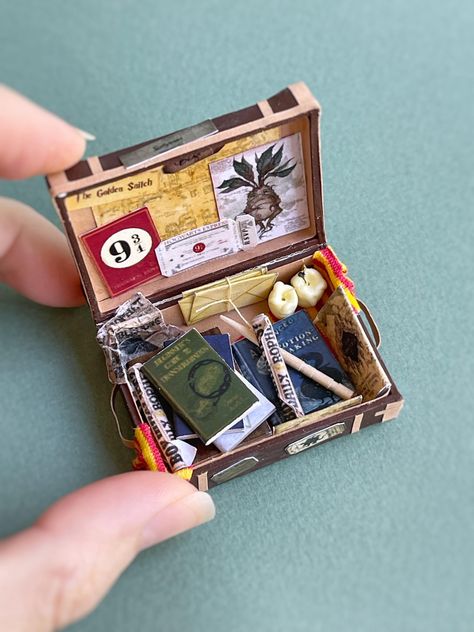 A miniature wizard's suitcase, scale 1:12, for a dollhouse. The set includes a suitcase decorated with stickers, books with spells, a magic wand, candles, a scarf and other magical decor. Each item is handmade, the set will be a great gift and decoration for a dollhouse, create the right mood. All items are fixed with glue Harry Potter Suitcase, Miniature Harry Potter, Diy Doll Suitcase, Mini Treasure Chest, Miniature Gifts, Doll Suitcase, Matchbox Crafts, Magical Decor, Wallet Craft