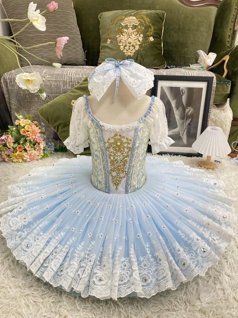 Professional bell-shaped tutu for the Wedding Pas de Deux in the ballet "Coppelia". White and pale blue brocade bodice with central white insert with gold decorations. Round neck decorated with white lace frills, pink and yellow flowers appliques, and pink satin ribbons. Round deep back and hooks and eyes closure. White short lace sleeves attached to the nude straps. The bell shaped tutu skirt is made with four layers of pastel color tulle (blue and pink), and features a white French lace overlay embellished with rhinestones. Custom made. Delivery time: 6 to 8 weeks. $ 650 White Ballet Tutu, Alice In Wonderland Ballet, Classical Ballet Tutu, Dance Comp, Ballet Tutus, Gold Decorations, Ballerina Costume, Pink And Yellow Flowers, White Tutu