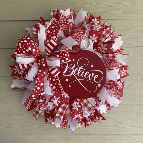 "Believe in the Magic...Red and White come together creating this modern Merry Christmas holiday wreath. This full sized wreath measures 26 inches in diameter and 9 inches deep. Created on a bed of red and white fabric mesh, this design features a 10\" round birch wood sign painted in scarlet red with the word \"Believe\" in crisp white script vinyl lettering. Coordinating red and white premium wired ribbon streamers surround the sign creating a modern Christmas feel. Dimensions height: 26\" x w Ideas For Christmas Wreaths, Red And White Christmas Wreaths, Red And White Christmas Wreath Ideas, Making Christmas Wreaths, White And Red Christmas Wreath, Whimsical Christmas Wreath, Noel Wood Sign, Valentines Wreaths, Xmas Wreaths For Front Door