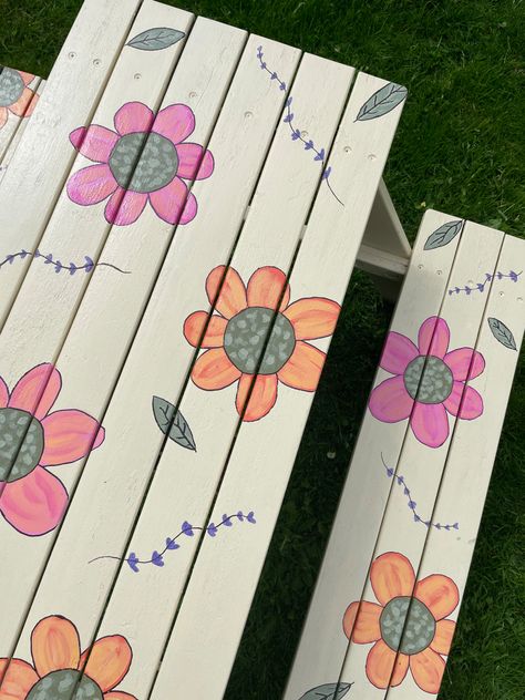 Hand painted flowers on kids picnic bench. In the background you can see greenery in a garden Painted Benches, Kids Picnic, Picnic Bench, Hand Painted Flowers, Painted Flowers, Picnic Table, Bench, Hand Painted, Flowers