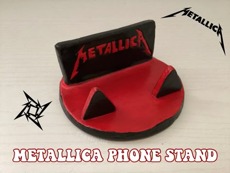 Phone stand made out of air dry clay. Red and black, says Metallica on the front. Air Dry Clay Guitar, Polymer Clay Phone Stand, Air Dry Clay Phone Stand, Grunge Clay Ideas, Clay Phone Stand, Airdryclay Ideas, Bf Gift, Room Crafts, Theme Phone