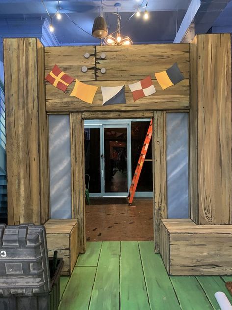 The door frame is outfitted with oversized wood planks with cartoony wood grain. Massive nails can be seen at the top of the frame connecting the wood into place. Hanging from the frame are five flags in a downward arch. The exterior windows of the "building" are painted to appear like cartoony blue glass. Krusty Krab Party, Scary Spongebob, Minecraft Krusty Krab Inside, Krusty Krab Interior, Spongebob Krusty Krab, Krusty Krab Gingerbread House, The Krusty Krab Restaurant, The Krusty Krab, Krusty Krab