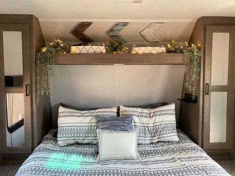 RV bedroom decor, fairy lights, plants in an RV, camper bedding, rv decor Travel Trailer Bedroom Decor, Camper Bedroom With Window Behind Bed, Camper Bunk Bed Decorating Ideas, Small Camper Bedroom Remodel, Camper Bunkhouse Decor, Modern Camper Decor, Travel Trailer Master Bed Remodel, Rv Shelf Above Bed, Camper Bedroom Remodel Ideas