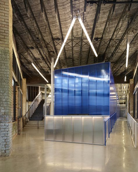 View from the flatiron entry towards the reception desk. The blue polycarbonate office core defines new vs. historic. The original exposed metal lath and concrete deck above remains. Floors are polished concrete. Industrial Reception Desk, Office Transformation, Concrete Deck, Reception Desk Design, Flatiron Building, Hotel Interiors, Commercial Architecture, Brick Building, Polished Concrete