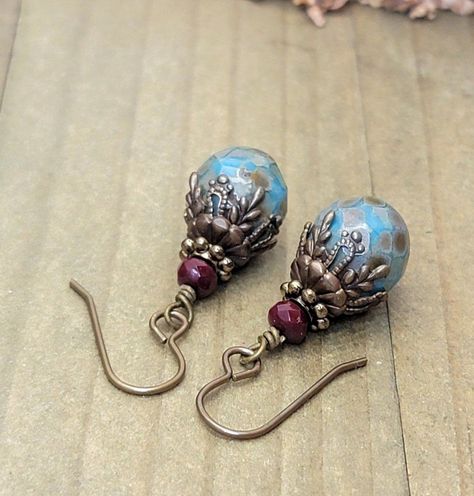 These Rustic Boho Turquoise Czech Dangle Earrings are delicately hand crafted from turquoise and deep red Czech glass beads, with beautiful brass accents. They capture a rustic, boho style, with an ornate finish. Uniquely gorgeous! Turquoise faceted Czech glass beads Deep red faceted Czech glass beads Vintaj antique...#HandmadeJewelry #Exploring #JewelryLovers #StatementJewelry #Jewelry #Style #Boho #Jewelry #Bohemian #Accessories #JewelryAddict #Spirit #Embrace #Your #Free #with #Accessories Czech Glass Bead Earrings, Wire Earrings Handmade Diy, Boho Earrings Diy, Diy Earrings Dangle, Thigh Jewelry, Czech Beads Jewelry, Boho Jewelry Diy, Earrings Diy Handmade, Czech Glass Jewelry